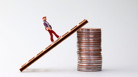 The miniature woman is climbing up to the pile of coins with a ladder. The concept of the gap...