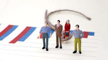 Bar charts and miniature people. The concept of discrimination against women in employment and work.の写真素材