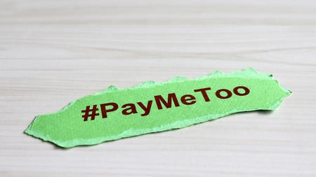 #PayMeToo as a new social movement. A piece of paper with #PayMeToo written on the wood table.の写真素材