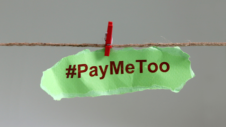 #PayMeToo as a new social movement. A piece of paper with #PayMeToo written on a clothesline.の写真素材