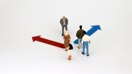 Two different directions and miniature people. Employment standards differentiation concept between men and women.の写真素材