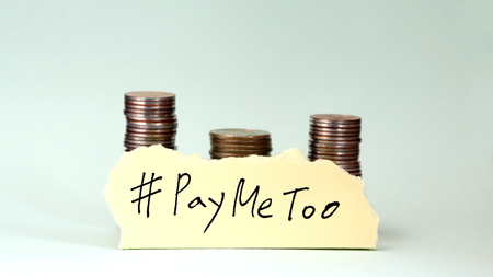 #PayMeToo as a new campaign to close the wage gap between men and women. Handwritten letter #PayMeToo on torn paper with pile of coins.の写真素材