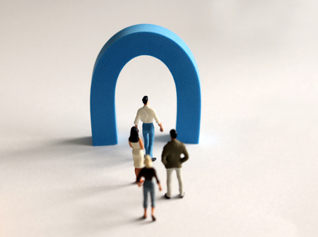 The miniature people walking lined up in front of a small gate. The concept of narrow employment.の写真素材