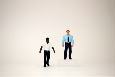 The concept of invisible barriers by the labor market. Two miniature businessmen.の写真素材