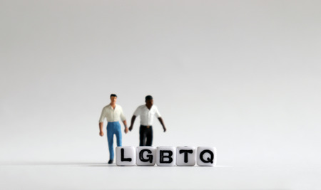 White cubes with 'LGBTQ' words. White cubes and miniature people.の写真素材