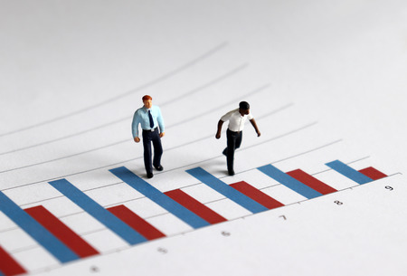 The miniature men standing on a bar graph.の写真素材