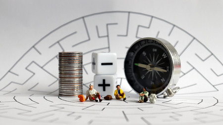 Miniature tourists sitting on a maze.の写真素材