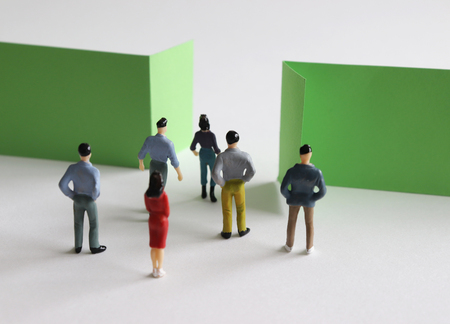 Miniature people standing at the narrow entrance.の写真素材