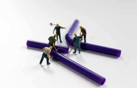 Disposable straws and miniature people. Concept of difficulties in disposable plastic product disposal.の写真素材