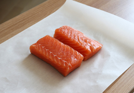 Two loaves of raw salmon on paper.