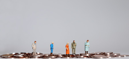 Old age people miniature walking on coins.