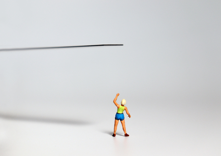 A miniature woman pointing at the edge of a cliff.の写真素材