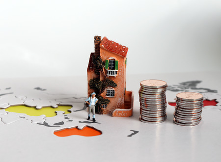A concept about travel expenses. A pile of coins and miniature people.の写真素材