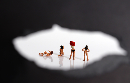 Miniature women changing clothes. The concept of stealthy criminal behavior.の写真素材