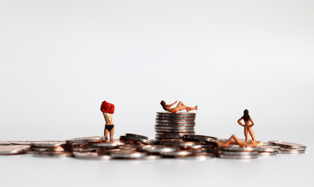 Stop selling women. Coins and miniature women. The concept of women's human rights violations.の写真素材