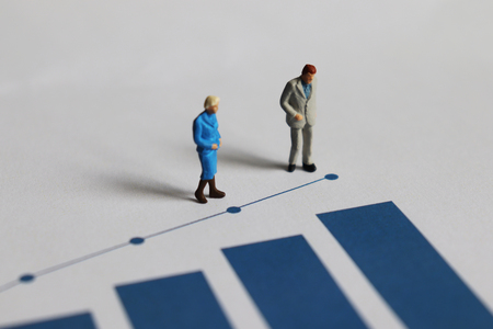 Miniature older people and blue bar graph.の写真素材