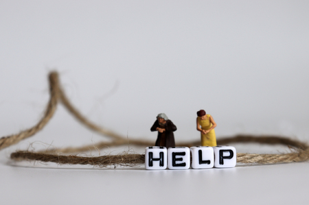 A HELP text alphabet cube in a rope. Miniature people.の写真素材