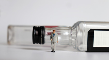 Miniature people and the liquor bottle.の写真素材