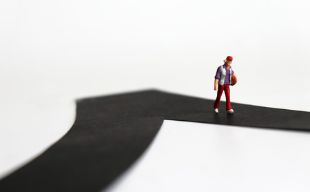 A miniature woman walking along the street.
