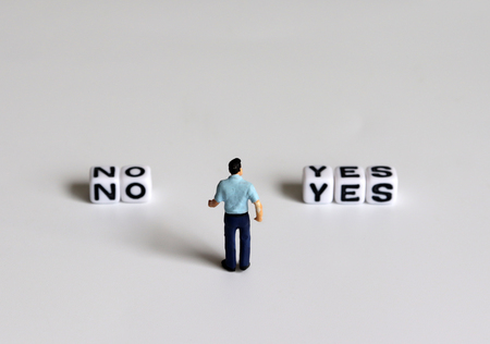 YES and NO text alphabet white cube. Miniature people.の写真素材