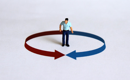 A miniature man standing in a circle with an arrow.
