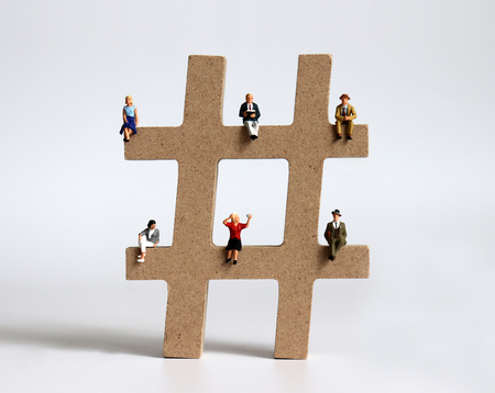 A variety of miniature people sitting on hash tags.の写真素材