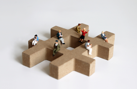 Miniature people sitting on the block of # symbolic trees.の写真素材