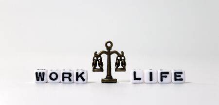 A miniature scale between WORK word and LIFE word on white cubes.の写真素材