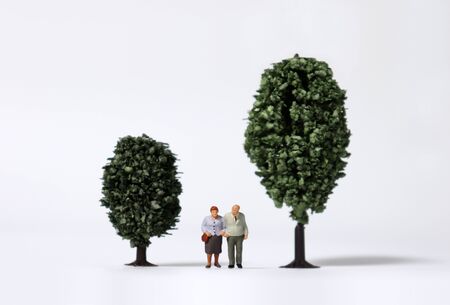 Old age miniature people walking between miniature trees.の写真素材