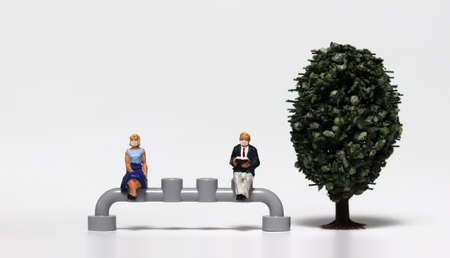 Miniature people sitting wearing masks. Concepts about the importance of wearing a mask and sitting...
