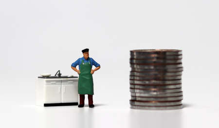 A pile of coins and a miniature people. The concept of disaster support for self-employed people.