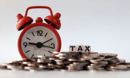 coins, clock and tax on background.