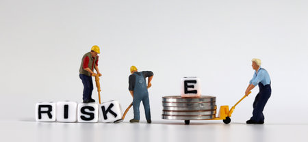Miniature people who change cubes with RISK into RISE. Miniature man carrying E and coins in a cart.の写真素材