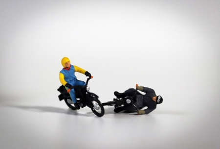 Miniature motorcycle rider. Miniature motorcycle driver who crashed. Concept about the risk of motorcycle accidents.の写真素材