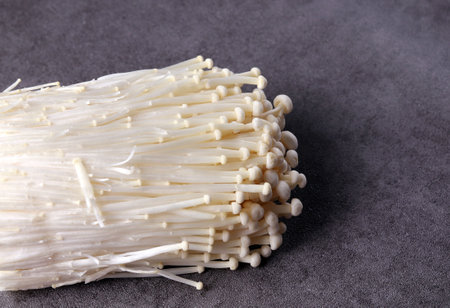 Fresh enoki mushrooms in the dark background. Vegetables and ingredients.の写真素材