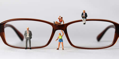 Business concept with glasses and miniature people. The concept of gender discrimination and prejudice.の写真素材