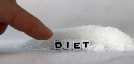 White cube arranged in the word 'DIET' with sugar. The concept of reducing sugar intake.の写真素材
