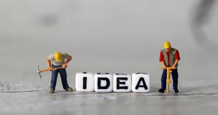 White cube with the word 'IDEA'. IDEA and miniature people with business concept.の写真素材