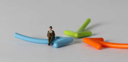 A miniature man sitting on an arrow. Miniature and business concept.の写真素材