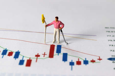 Business concept with graphs and miniature people. A miniature man on the graph.