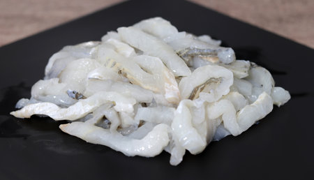 Raw fish on a black plate. Fresh sashimi. A close-up shot of fresh sashimi.の写真素材