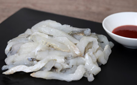 Sashimi and red pepper paste on a black plate. A close-up shot of fresh sashimi.の写真素材