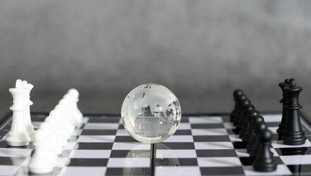 A globe and a pawn on a chessboard. Worldwide Tactical and Strategic Concepts.