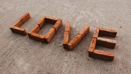 A brick letter of love on the ground , with warming tone, slope letter. clockwise