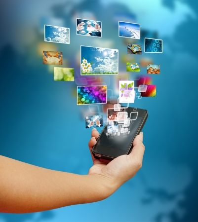 hand women touch smart phone in hand on blue background の写真素材