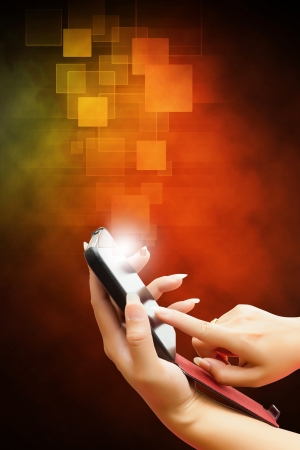 hand of business women pushing on a touch screen interface on smart phone  isolated orange backgroundの写真素材