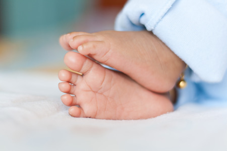 Newborn baby feet on white 