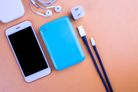 Smart phones and devices that placed on the table, background color orange.の写真素材