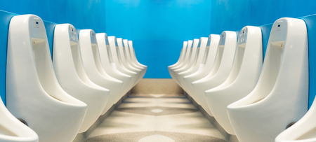 Modern public toilets Interiors A row of urinals urinating on a blue backgroundの写真素材