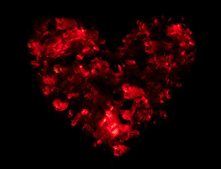 Love symbolised by a red passionate heart made of embers.の写真素材